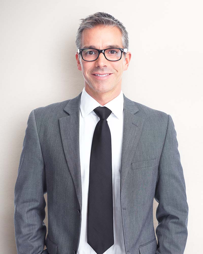 Handsome smiling businessman over gray banner background.