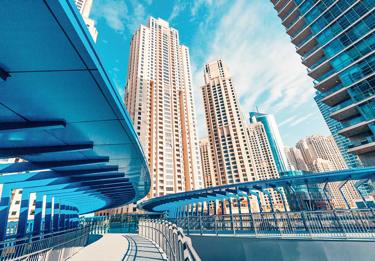 The tallest residential block in the world - Jumeirah Beach Residence and original architecture pedestrian bridge in Dubai. Residential real estate and development
