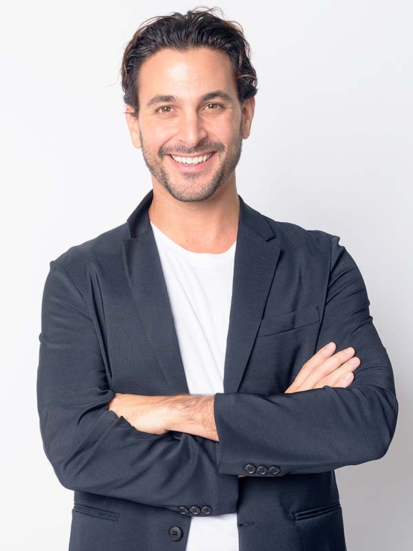 Studio shot of handsome Hispanic businessman wearing suit against white background