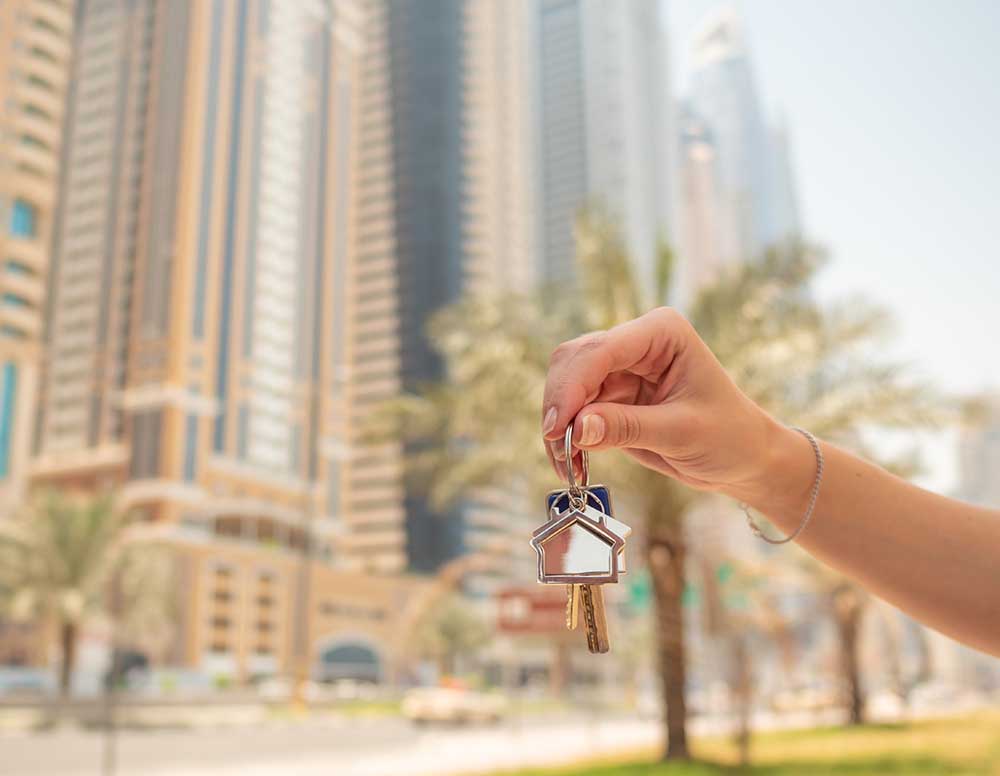 Hand girl holds the keys. The concept of buying an apartment or car in Dubai. Hand close-up